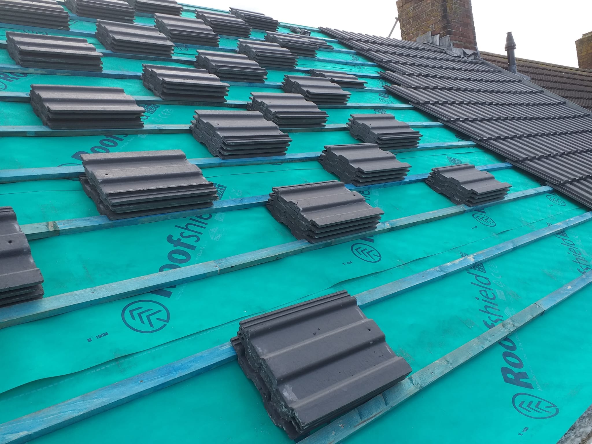 grey tiled roof install in progfress